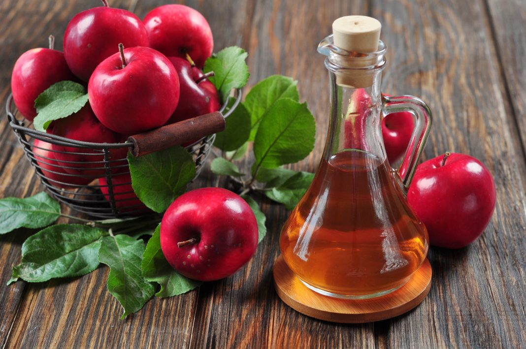21757250 - apple cider vinegar in glass bottle and basket with fresh apples
