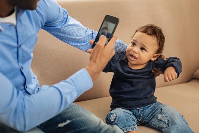 Daddy taking photos of his cute son