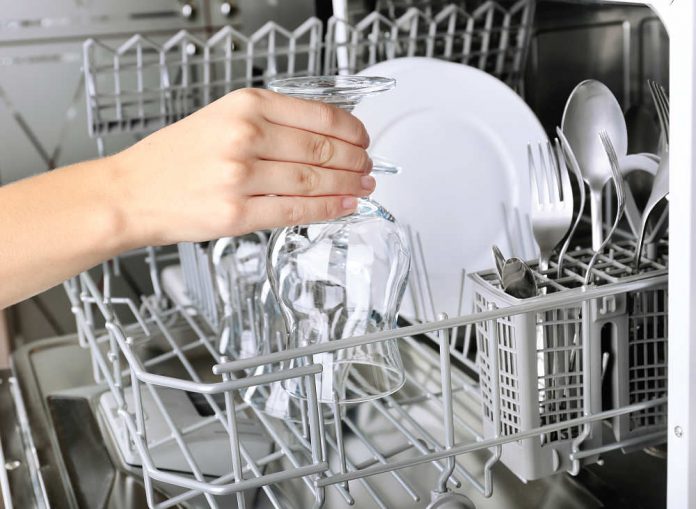 Open dishwasher with clean utensils in it